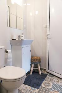 a bathroom with a toilet and a sink and a stool at Balabanov White in Varna City +26 photos