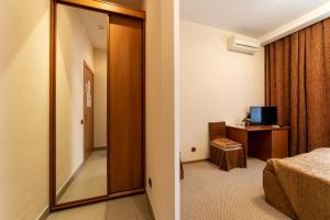 エカテリンブルクにあるOnezhsky Hotelの鏡付きの部屋、ベッド付きのベッドルーム1室が備わります。