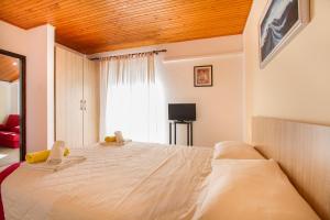 a bedroom with a large bed with a wooden ceiling at Weis Apartments in Rovinj