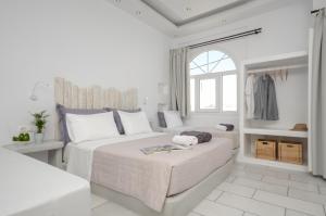 a white bedroom with two beds and a window at Naxos Dream Oniro Studios - Adults Only in Naxos Chora