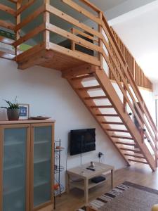a wooden staircase in a living room with a table at Apartment Niko in Vir