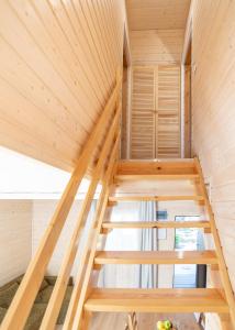 a wooden staircase in a tiny house at Hubertus Pogorzelica - domki przy plaży in Pogorzelica