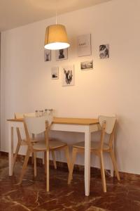 a dining room table with two chairs and a lamp at Atico centro Alicante in Alicante +6 photos