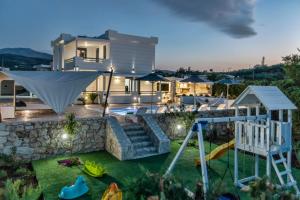 a house with a backyard with a playground at Villa Green Diamond - Private Heated Pool in Platanes