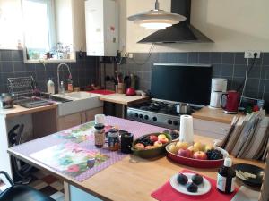 a kitchen with a table with a bowl of fruit on it at Chambres Zola in Nantes