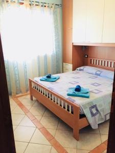 1 dormitorio con 1 cama con 2 toallas en Appartamento Blue Marine en Porto Pino
