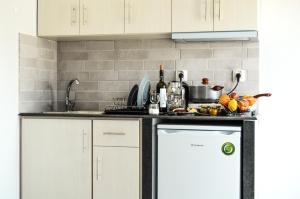 a kitchen with white cabinets and a white dishwasher at Gatos Village Studios & Apartments in Asprovalta +40 photos