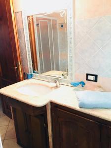 y baño con lavabo y espejo. en Appartamento Blue Marine en Porto Pino