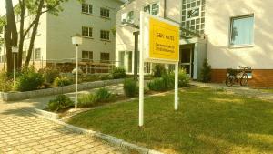a yellow sign in the grass in front of a building at Hotel G&K in Giesen