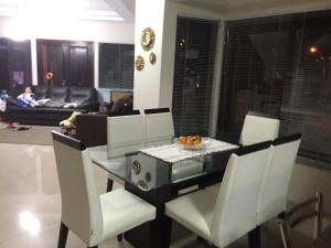a dining room with a table and white chairs at Casa em praia de Garopaba 48- in Garopaba