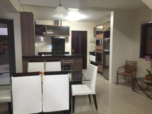 a dining room and kitchen with a table and chairs at Casa em praia de Garopaba 48- in Garopaba +29 photos