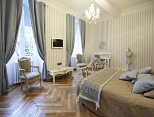 a bedroom with a bed and a table and chairs at Maison d'hôtes "Les Jardins de Mazamet" in Mazamet