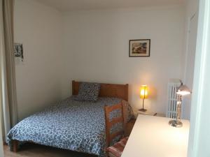 a small bedroom with a bed and a table at Chambres Zola in Nantes
