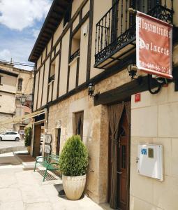un bâtiment avec un panneau sur son côté dans l'établissement Alojamientos Palacete, à Peñaranda de Duero