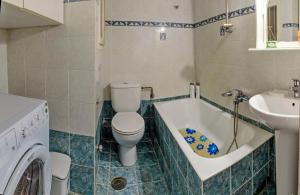 łazienka z toaletą, umywalką i pralką w obiekcie Cosy apartment for 4 w Atenach