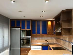 cocina con armarios de madera y nevera de acero inoxidable en Best apartment near REAL MADRID Stadium en Madrid