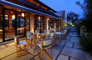 een restaurant met tafels en stoelen op een patio bij Maca Villas & Spa Bali in Seminyak