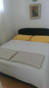 ein weißes Bett mit gelben Kissen in einem Zimmer in der Unterkunft Apartment Bella in Split