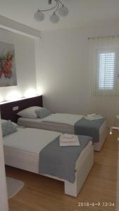 1 dormitorio con 2 camas y ventana en Apartments Niana with heated seawater swimingpool, en Okrug Donji