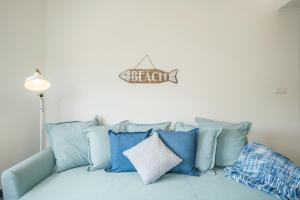 SilveiraにあるCasas da Avó IVの白い壁に青い枕が付いた青いソファ