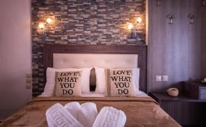 a bed with love what you do pillows on it at House Katerina Mediterranean in Sarti