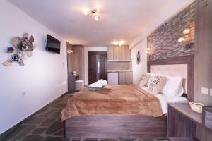 a bedroom with a large bed and a brick wall at House Katerina Mediterranean in Sarti