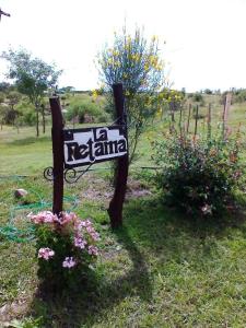 una señal en medio de un campo con flores en cabaña La Retama en Villa Yacanto