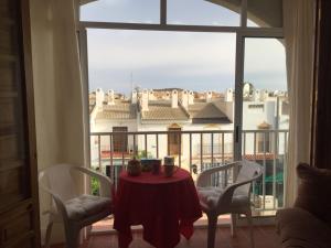プエルト・デ・マサロンにあるAlojamiento en Puerto Solのテーブルと椅子2脚、景色を望む窓が備わります。