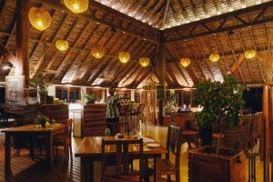 a restaurant with wooden tables and chairs and lights at White Grass Ocean Resort & Spa in Tanna Island