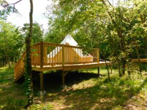 a wooden deck in the middle of a forest at Glampin' In Style-Broken Bow in Broken Bow