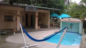a swimming pool with a slide in front of a building at Mapi's House in Paquera