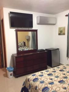 a hotel room with a bed and a television at Country Family in Culebra