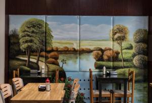 a room with tables and a painting of a river at Hotel Vial Center in Mar del Plata