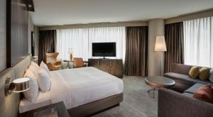 シカゴにあるハイアット セントリック シカゴ マグニフィセント マイルの大きなベッドとソファが備わるホテルルームです。
