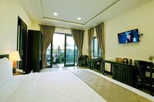 ホイアンにあるZen Hoian Villaの大型ベッドとテレビが備わるホテルルームです。