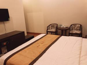 1 dormitorio con 1 cama, 2 sillas y mesa en Lucky Star Hotel, en Buon Ma Thuot