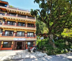 a large building with motorcycles parked in front of it at Hotel Forest Lake Backpackers' Hostel in Pokhara
