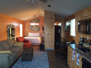 a living room with a bed and a kitchen at Westport Marina Cottages in Westport