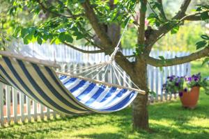 a blue and white hammock hanging from a tree at The Olive Garden in Limenas