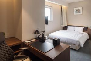 a hotel room with a bed and a desk at Clayton Bay Hotel in Kure