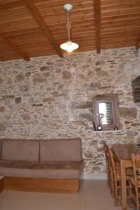 um quarto com uma parede de pedra, um sofá e uma mesa em Captain Nikolas em Keramotí