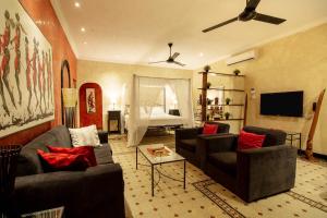 un salon avec deux canapés et une télévision dans l'établissement Mediterraneo Boutique Hotel, à Dar es Salaam