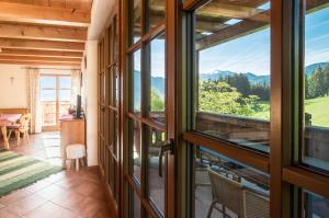 a room with a view of the mountains through windows at Ferienhof Margarethengut in Unterach am Attersee