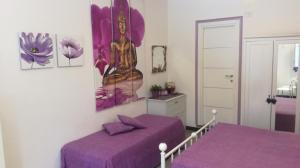 sypialnia z 2 łóżkami i fioletową pościelą w obiekcie Casetta Romantica Viola Lerici w mieście Lerici