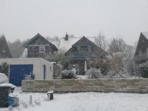 un patio cubierto de nieve con casas en Ferienwohnung auf dem Land Schermbeck Moviepark, en Schermbeck