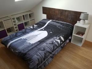 a bedroom with a large bed with a black comforter at Appartement Barcelonnette in Barcelonnette