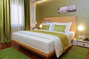 a bedroom with a large white bed with green accents at Boutique Hotel Bol in Bol +37 photos