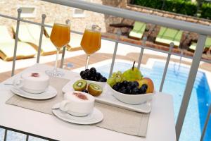 a tray of fruit and drinks on a table next to a pool at Boutique Hotel Bol in Bol