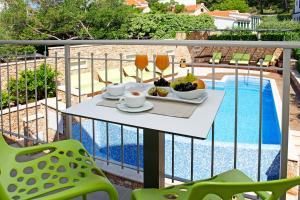 a table on a balcony next to a pool at Boutique Hotel Bol in Bol