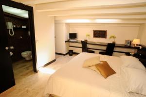 a bedroom with a bed and a desk with a computer at Ucciardhome Hotel in Palermo